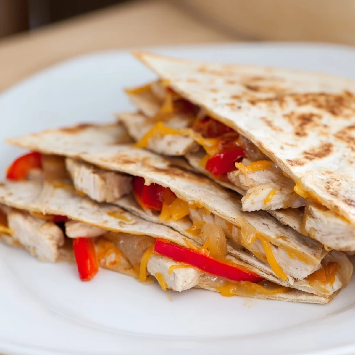 Golden-brown, cheesy Chicken Quesadilla cut into wedges, ready to be served hot with fresh toppings.
