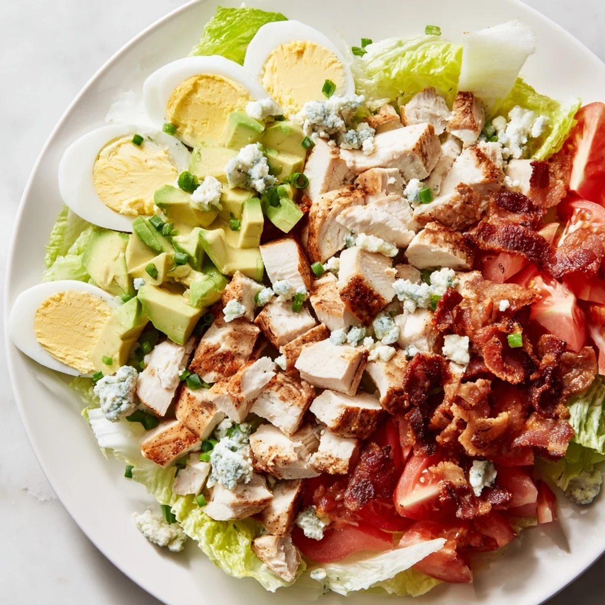 Delicious, visually appealing Cobb salad: layers of fresh ingredients and tangy dressing await your taste!