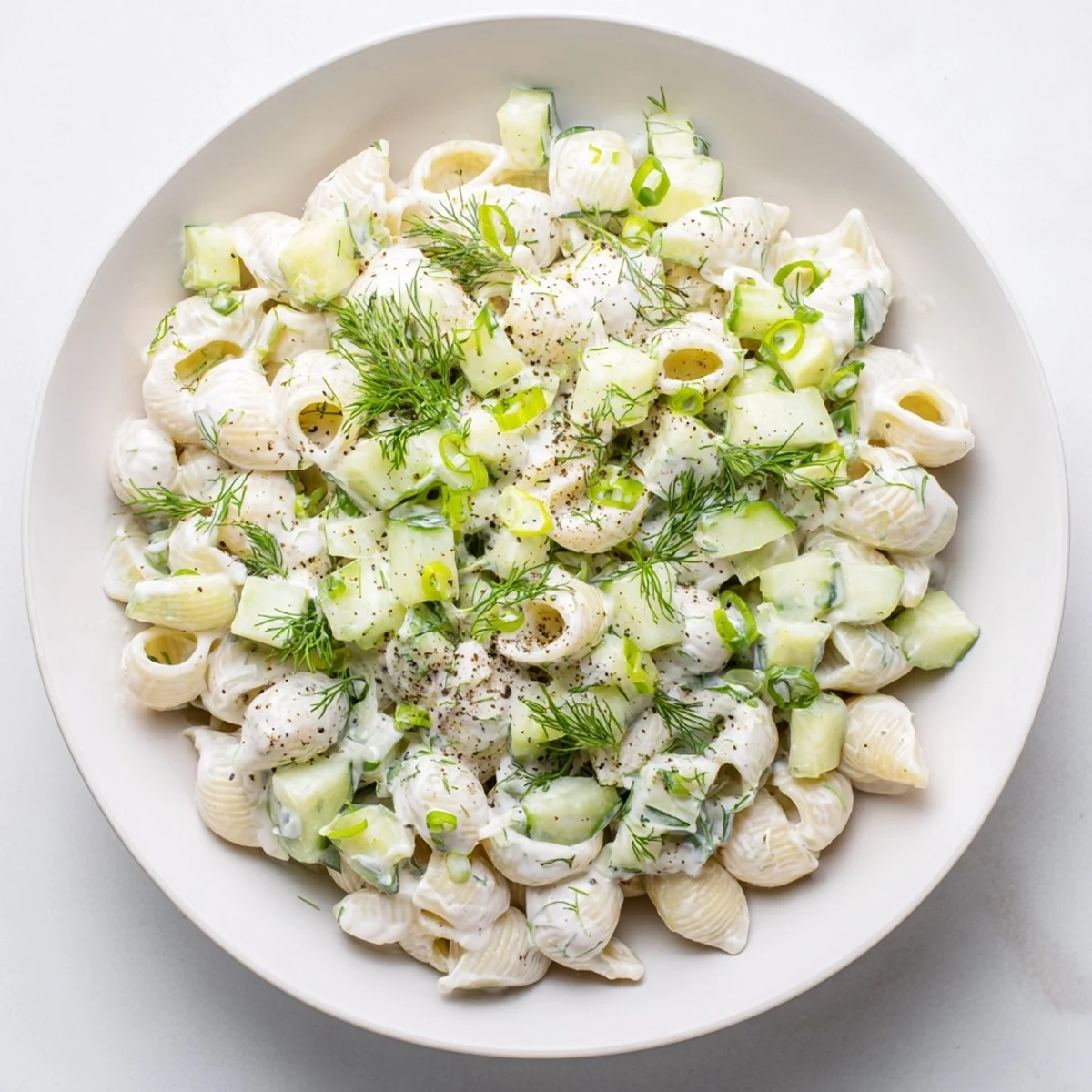 Creamy Cucumber Crunch Pasta Salad with tiny shells, crisp cucumbers, and fresh dill on a picnic table.  
