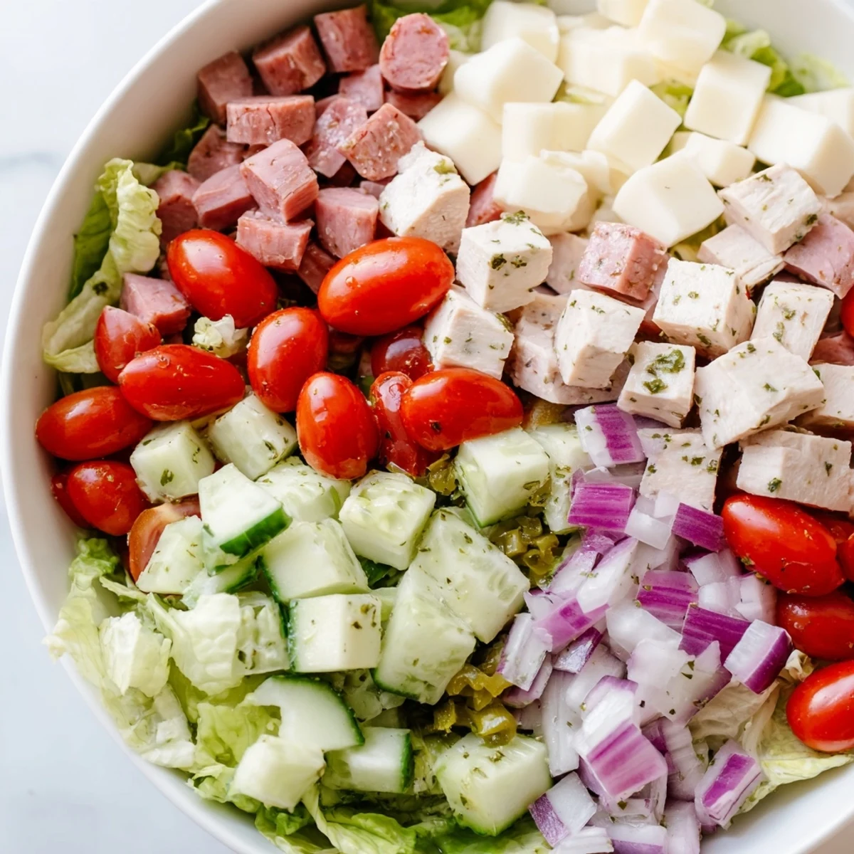 A vibrant Italian Deli Chopped Chicken Salad with chopped chicken, salami, provolone, and crisp romaine tossed in tangy herb dressing.