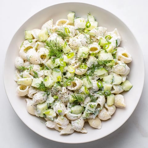 Creamy Cucumber Crunch Pasta Salad with tiny shells, crisp cucumbers, and fresh dill on a picnic table.  