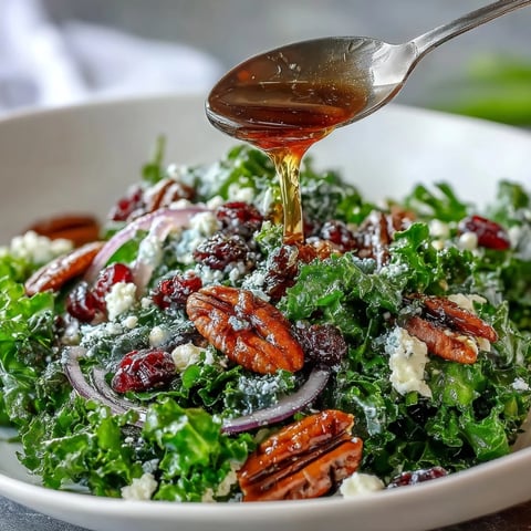 Warm Maple Mustard Kale Salad served on a rustic platter, featuring massaged green kale, toasted pecans, dried cranberries, and a drizzle of warm dressing.