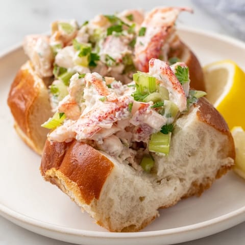Golden, toasted brioche roll overflowing with sweet, succulent New England lobster roll filling.