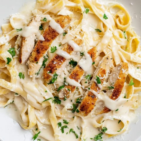A skillet of sizzling Cajun chicken Alfredo pasta showcases the rich, creamy sauce clinging to each strand of fettuccine.