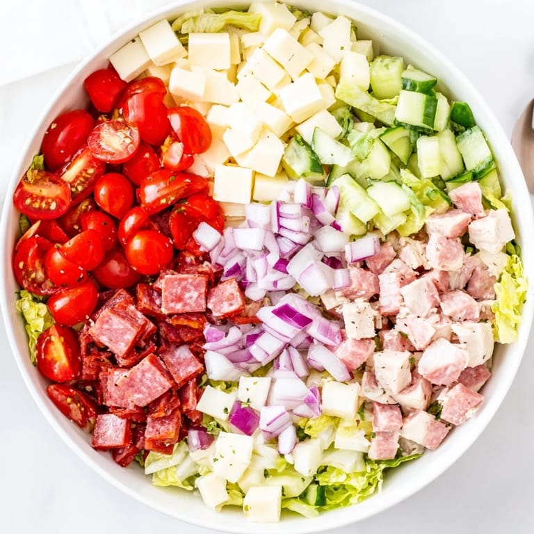 Hearty Italian Deli Chopped Chicken Salad served in a bowl, ready to enjoy, with olives and crusty Italian bread on the side.