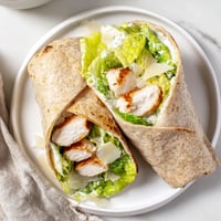 Grilled Chicken Caesar Wrap, beautifully assembled with vibrant greens, ready for a delicious bite.
