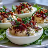 Creamy BLT deviled eggs with crispy bacon crumbles and fresh lettuce, a savory appetizer perfect for parties or brunch.